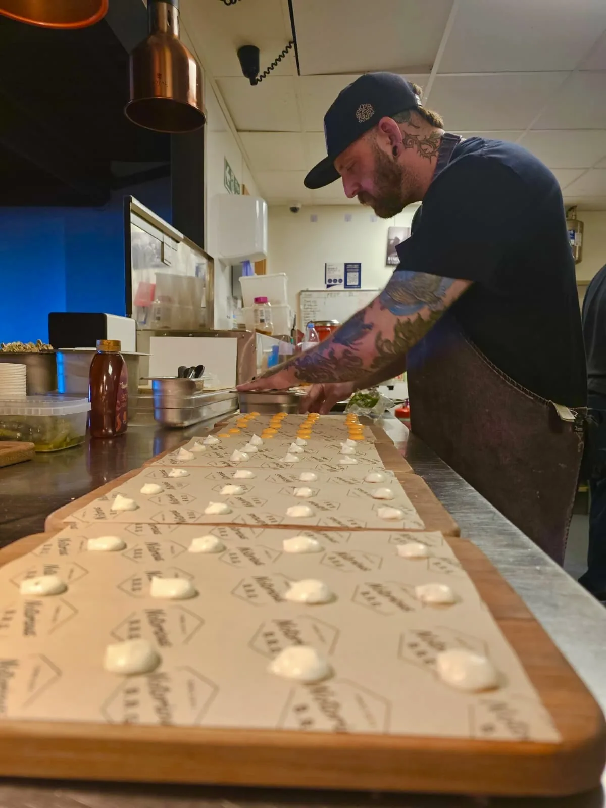 Notorious chef laying out long serving boards with sauce dots before a Kent catering job